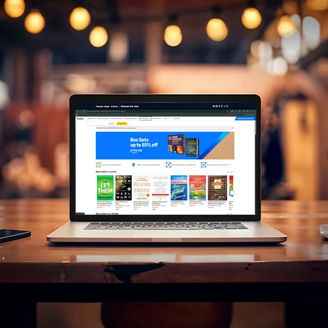 Laptop on a café table showing an Amazon books storefront